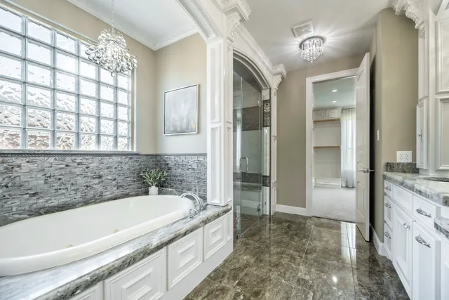 a spacious bathroom with a granite countertop tub sink and mirror