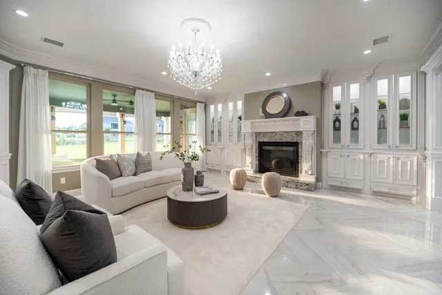 a living room with furniture a fireplace and a chandelier