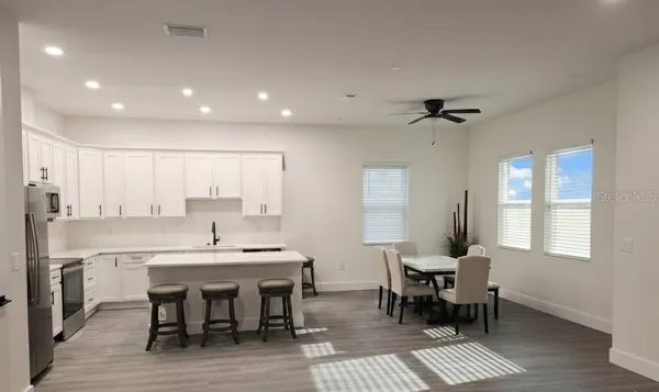 a view of a a dining room with furniture window and wooden floor