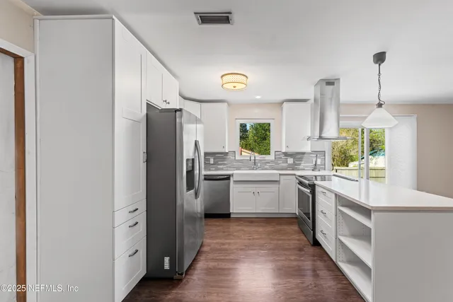 a kitchen with a refrigerator sink and cabinets