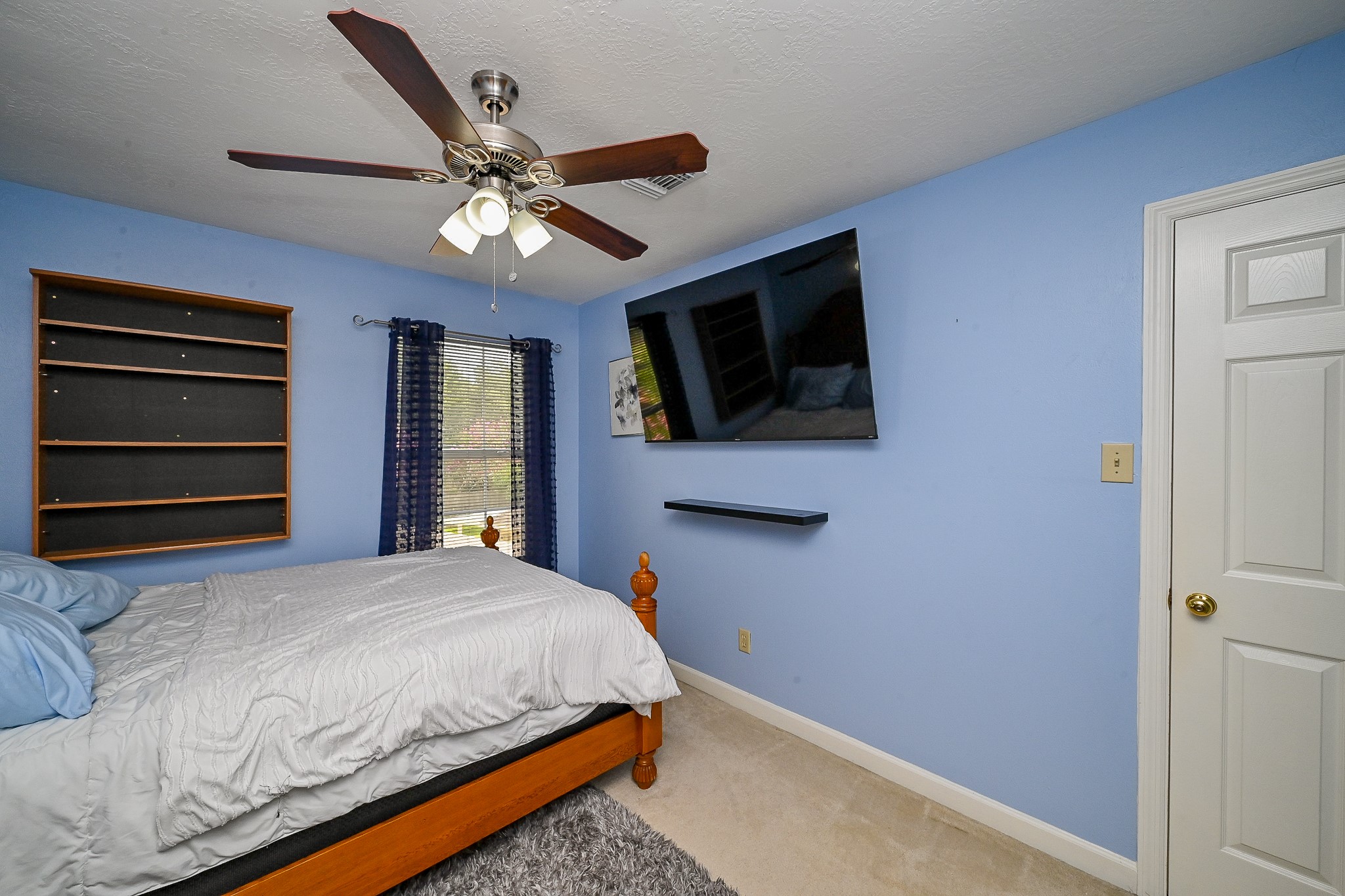 17518 Rustling Aspen Lane Houston, TX 77095 - Photo 21 of 39 a bedroom with a bed a flat screen tv and a ceiling fan