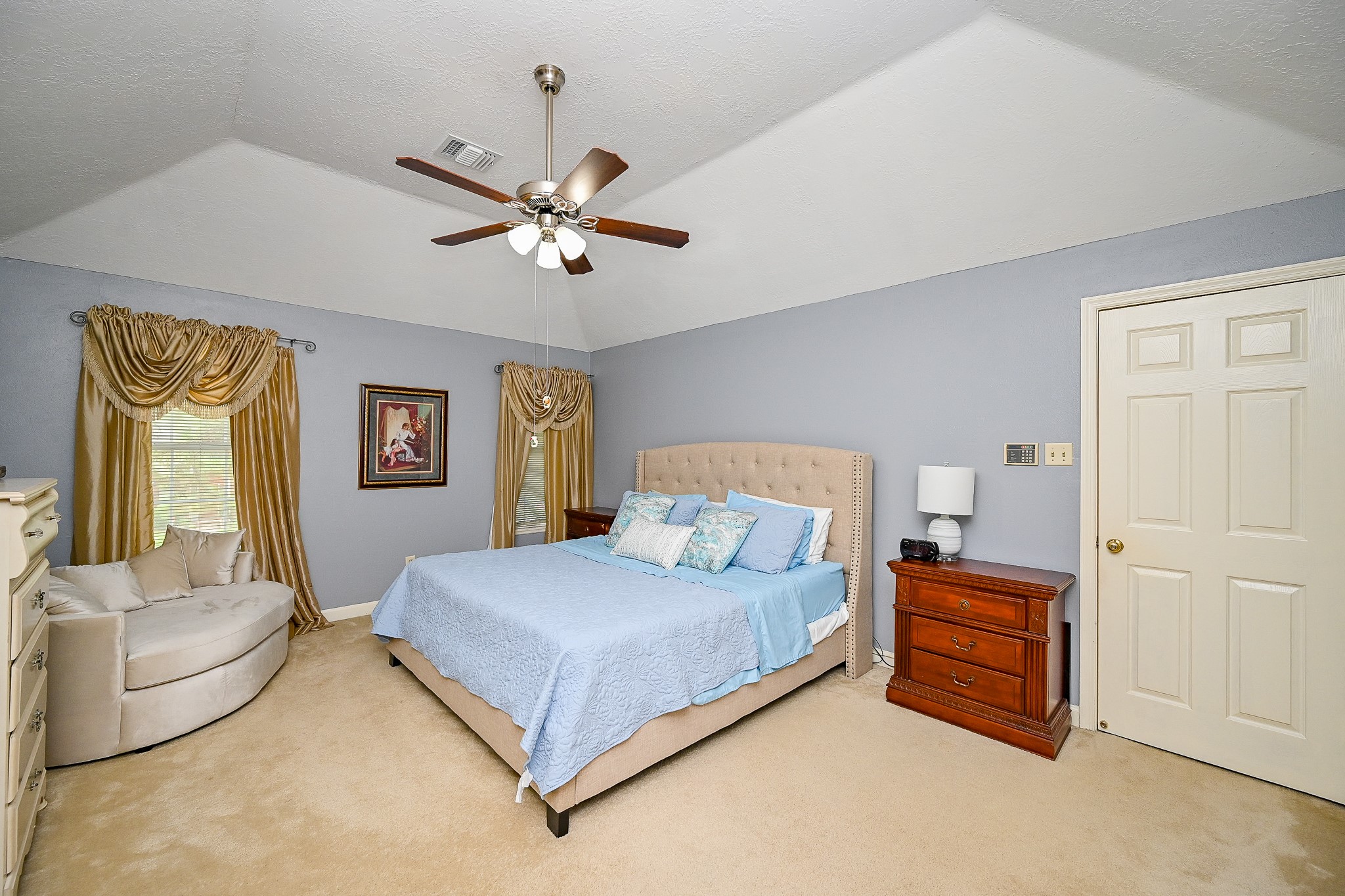 17518 Rustling Aspen Lane Houston, TX 77095 - Photo 28 of 39 a bedroom with a bed and a chandelier