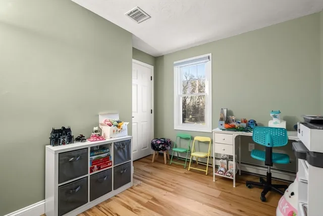 a view of a workspace with furniture and a window