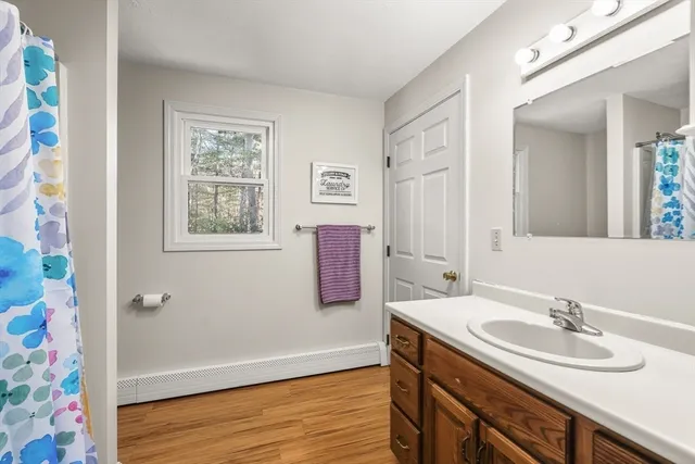 a bathroom with a sink vanity granite tub and a mirror