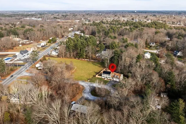 an aerial view of residential houses with outdoor space and trees