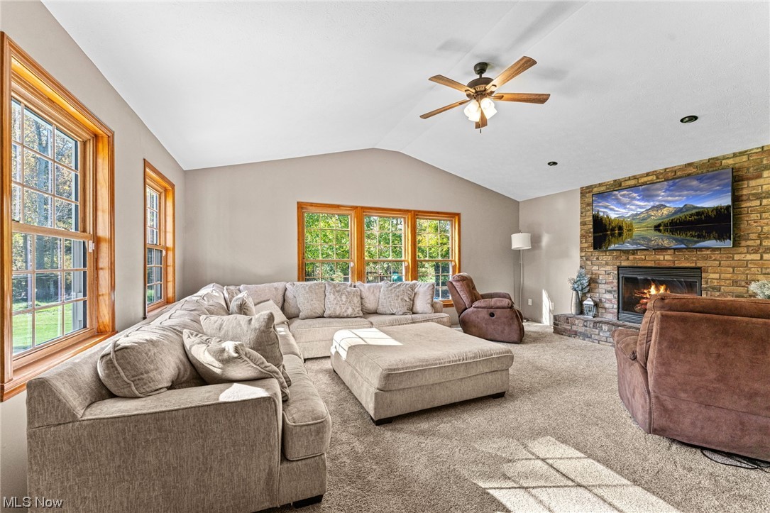 7534 Rice Road Amherst, OH 44001 - Photo 21 of 35 Living room with a wealth of natural light, ceiling fan, a fireplace, and vaulted ceiling