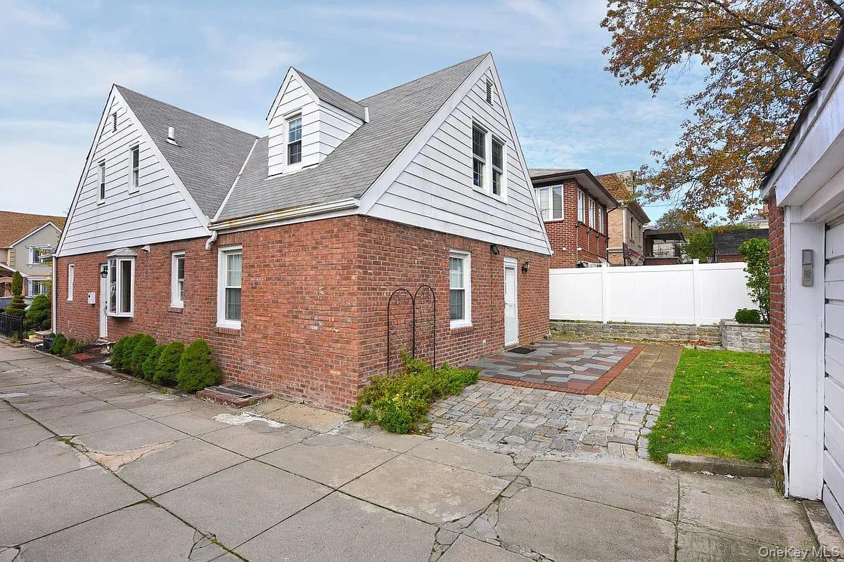 a view of a brick house with a yard plants next to a road