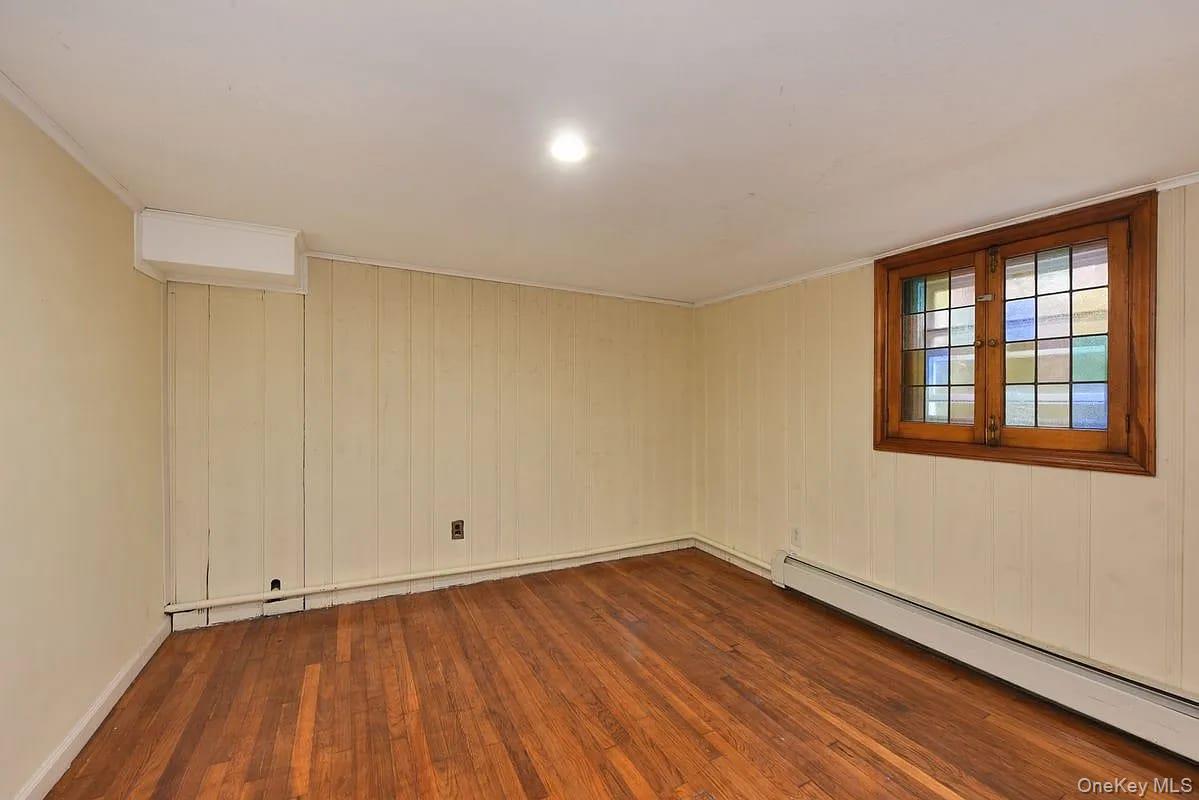 108-30 67th Avenue Queens, NY 11375 - Photo 23 of 29 a view of an empty room with wooden floor and a window