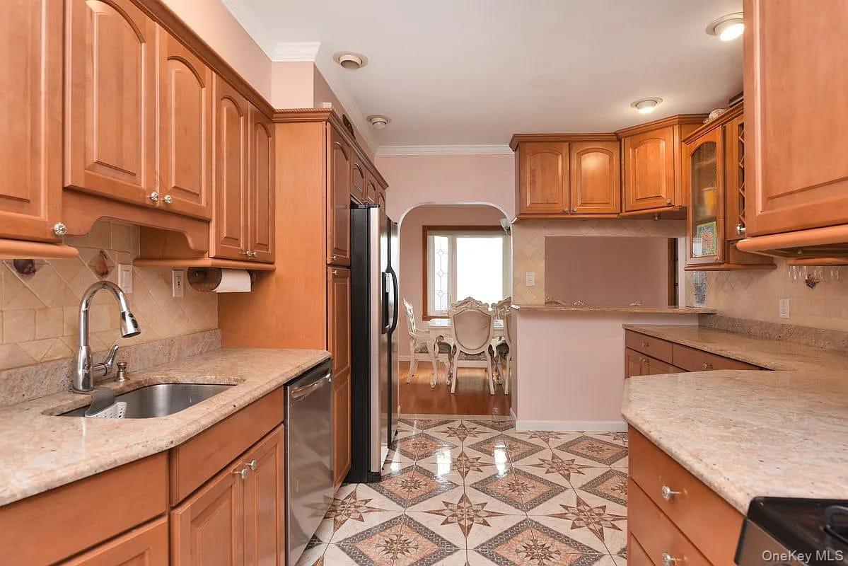 108-30 67th Avenue Queens, NY 11375 - Photo 8 of 29 a kitchen with stainless steel appliances granite countertop a sink refrigerator and cabinets