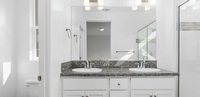 a bathroom with a granite countertop sink and a mirror