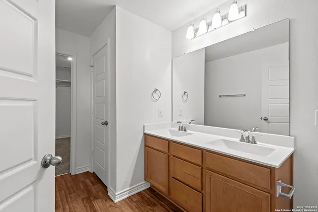 a spacious bathroom with a double vanity sink a mirror and a shower