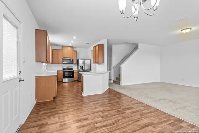 a view of kitchen and living room with wooden floor