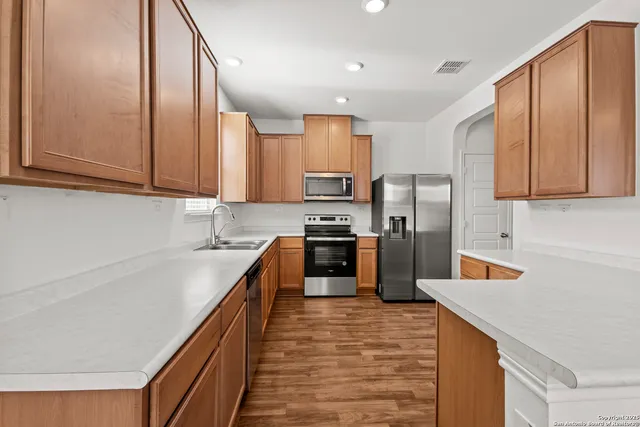 a kitchen with stainless steel appliances granite countertop a refrigerator sink and cabinets