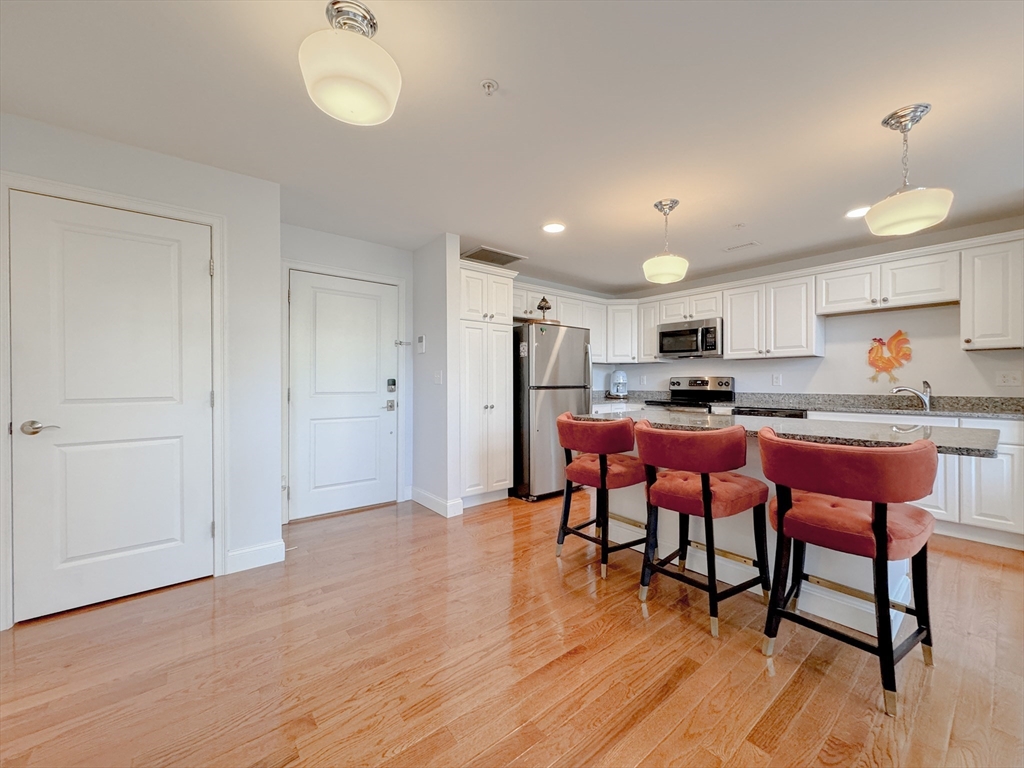 18 Eagle Nest Road, Unit 331 Clinton, MA 01510 - Photo 2 of 28 a kitchen with stainless steel appliances kitchen island granite countertop a table chairs sink and cabinets