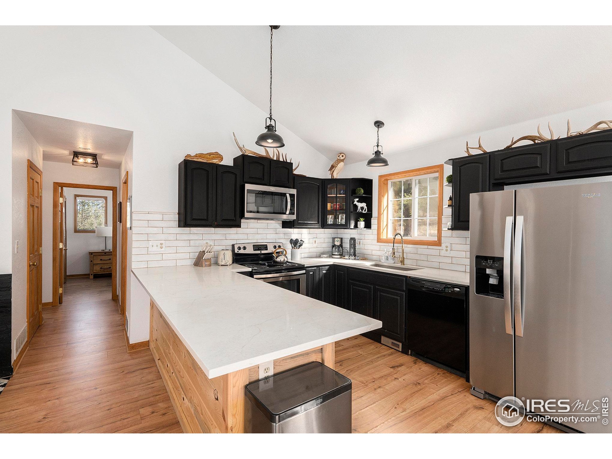 654 Piaute Way Como, CO 80432 - Photo 9 of 25 a kitchen with stainless steel appliances kitchen island granite countertop a refrigerator a sink dishwasher a stove and white cabinets with wooden floor