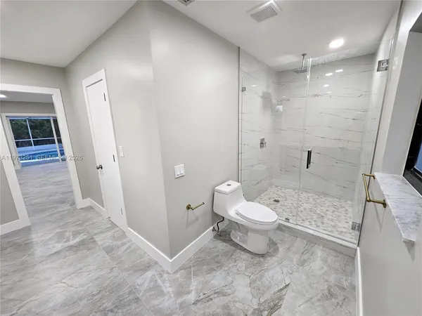 a room with lots of white furniture and shower