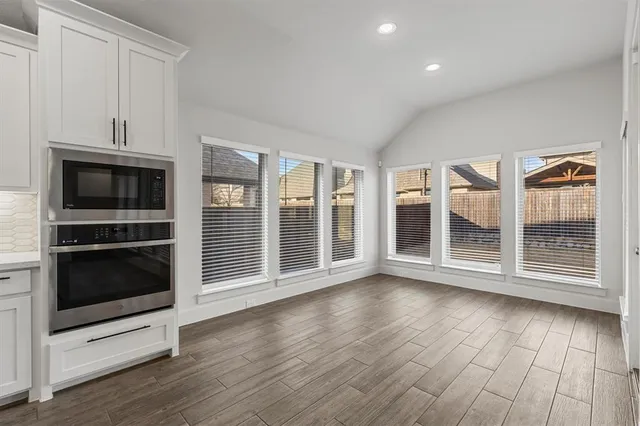 a view of wooden floor fireplace and windows in an empty room