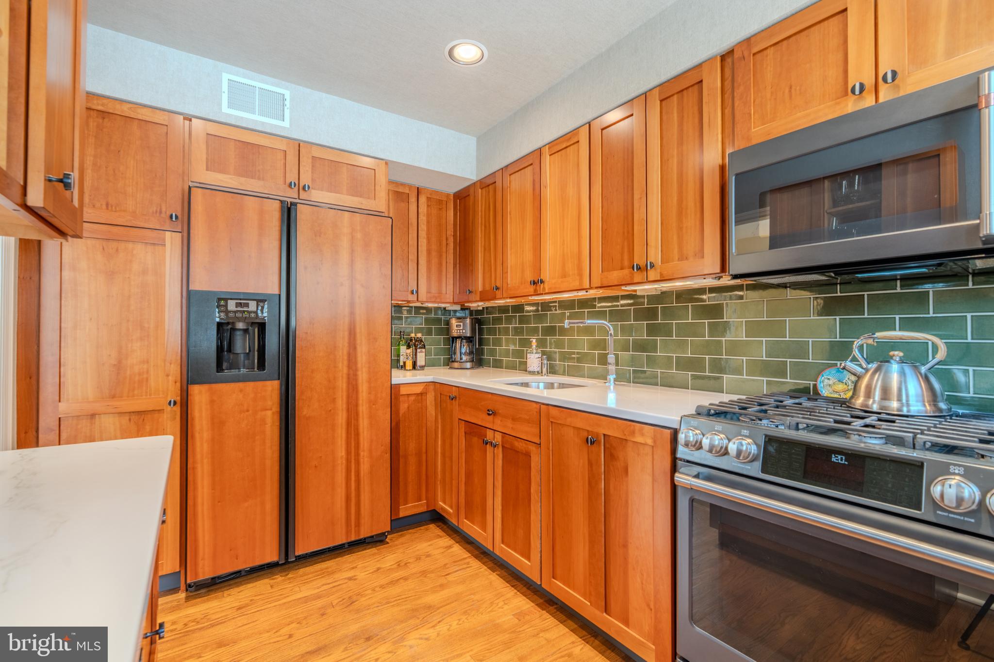 173 Hillview Drive Springfield, PA 19064 - Photo 11 of 50 a kitchen with stainless steel appliances granite countertop a stove a sink and a microwave