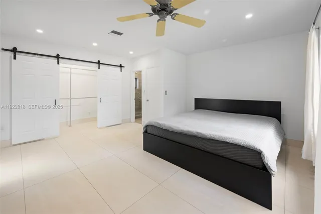 a bedroom with a bed and a ceiling fan