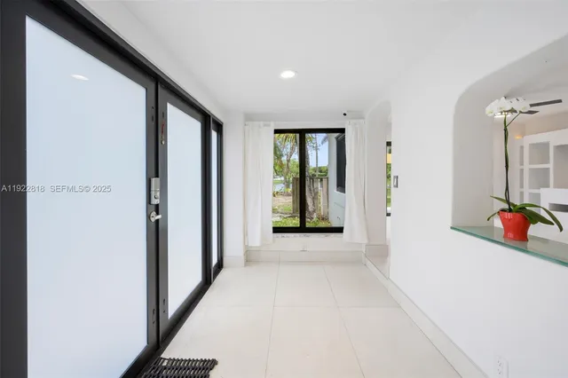 a view of a hallway and a livingroom with furniture