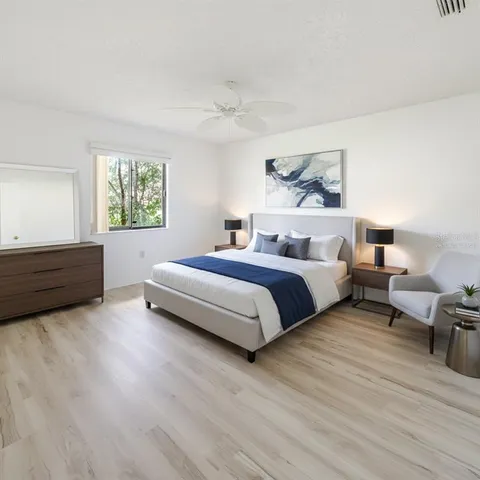 a spacious bedroom with a bed and a dresser