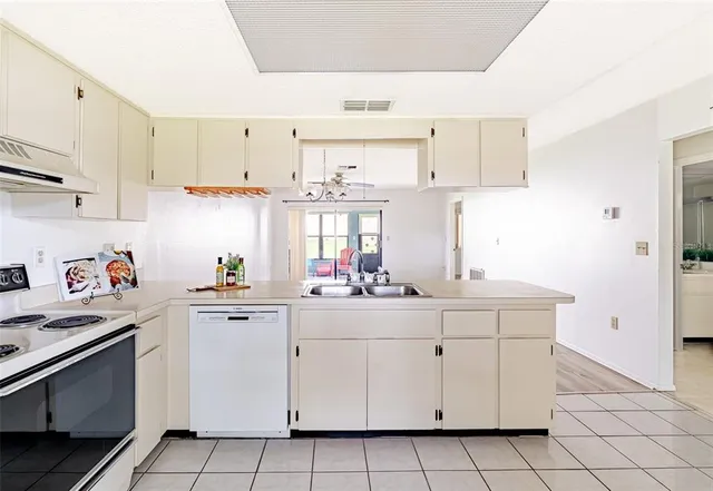 a kitchen with white cabinets sink and white appliances