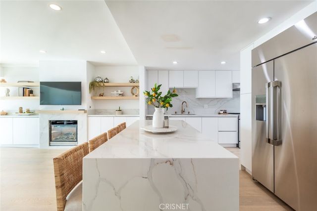 a kitchen with stainless steel appliances a refrigerator sink and white cabinets