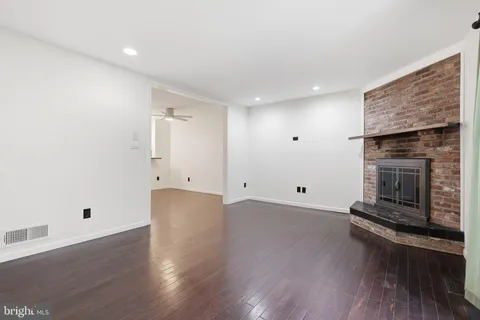 an empty room with wooden floor and fireplace
