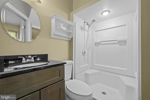 a bathroom with a granite countertop sink mirror toilet and bathtub