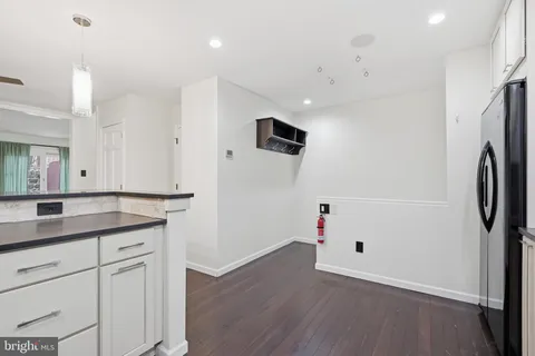 a kitchen with stainless steel appliances granite countertop a refrigerator sink and white cabinets