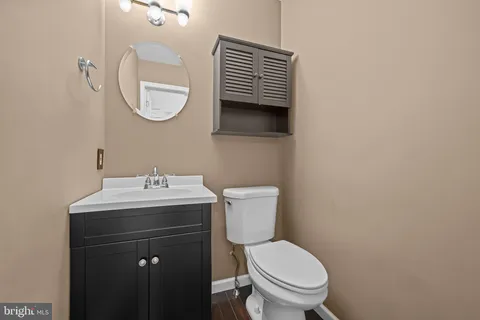 a bathroom with a toilet a sink and mirror
