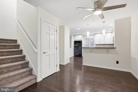 a view of a kitchen with wooden floor and a ceiling fan