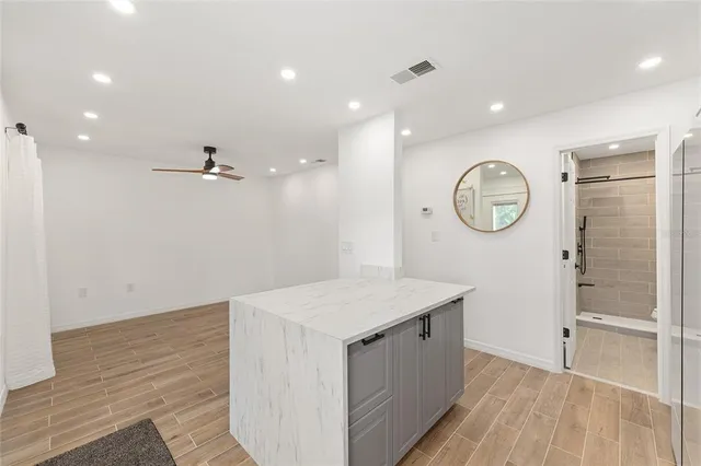 a view of a hallway to a room with wooden floor