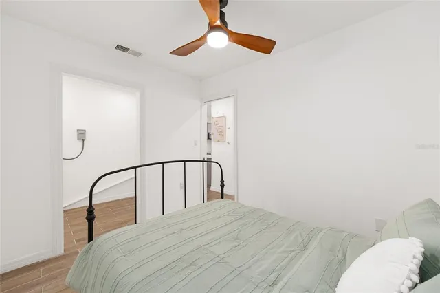 a bedroom with a bed and a chandelier fan