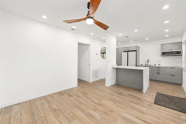 a view of kitchen with sink and refrigerator