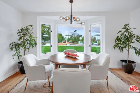 a dining room with furniture window and wooden floor