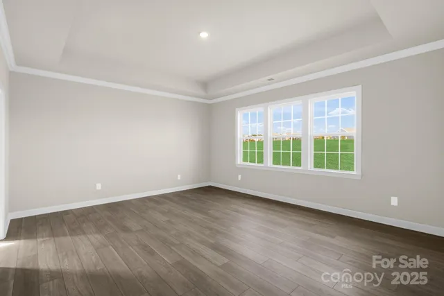 an empty room with windows and fireplace