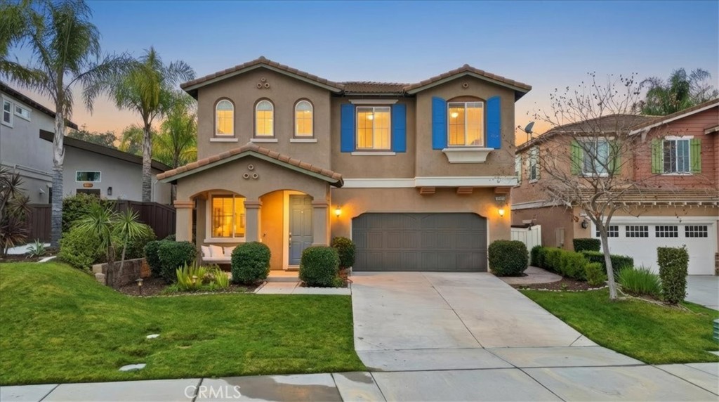 a front view of a house with a garden and plants