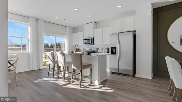 a kitchen with kitchen island stainless steel appliances a refrigerator and a dining table