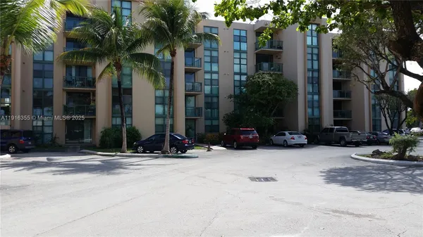 a view of a house with a yard and palm trees