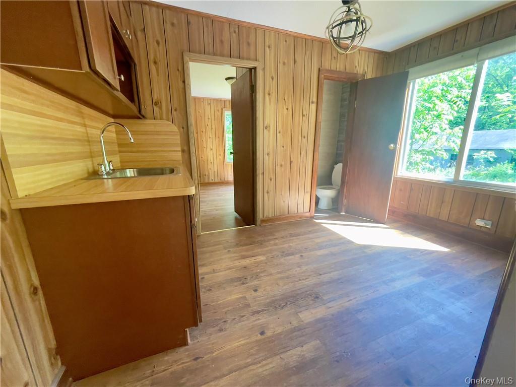 4 Old Turnpike Road Bloomingburg, NY 12721 - Photo 22 of 27 Kitchen featuring sink, wood walls, and hardwood / wood-style flooring