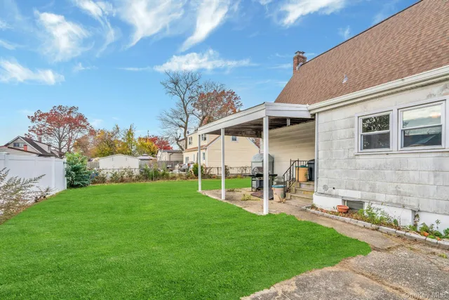a view of a chair and table in backyard of the house