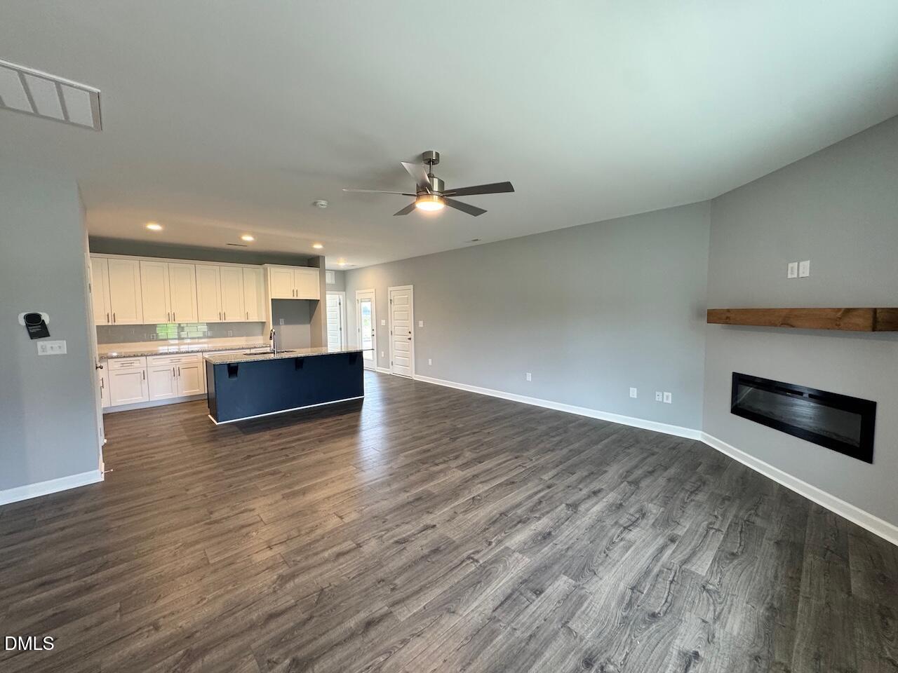 9 Alex Acres Way Selma, NC 27576 - Photo 3 of 26 an empty room with wooden floor and kitchen view