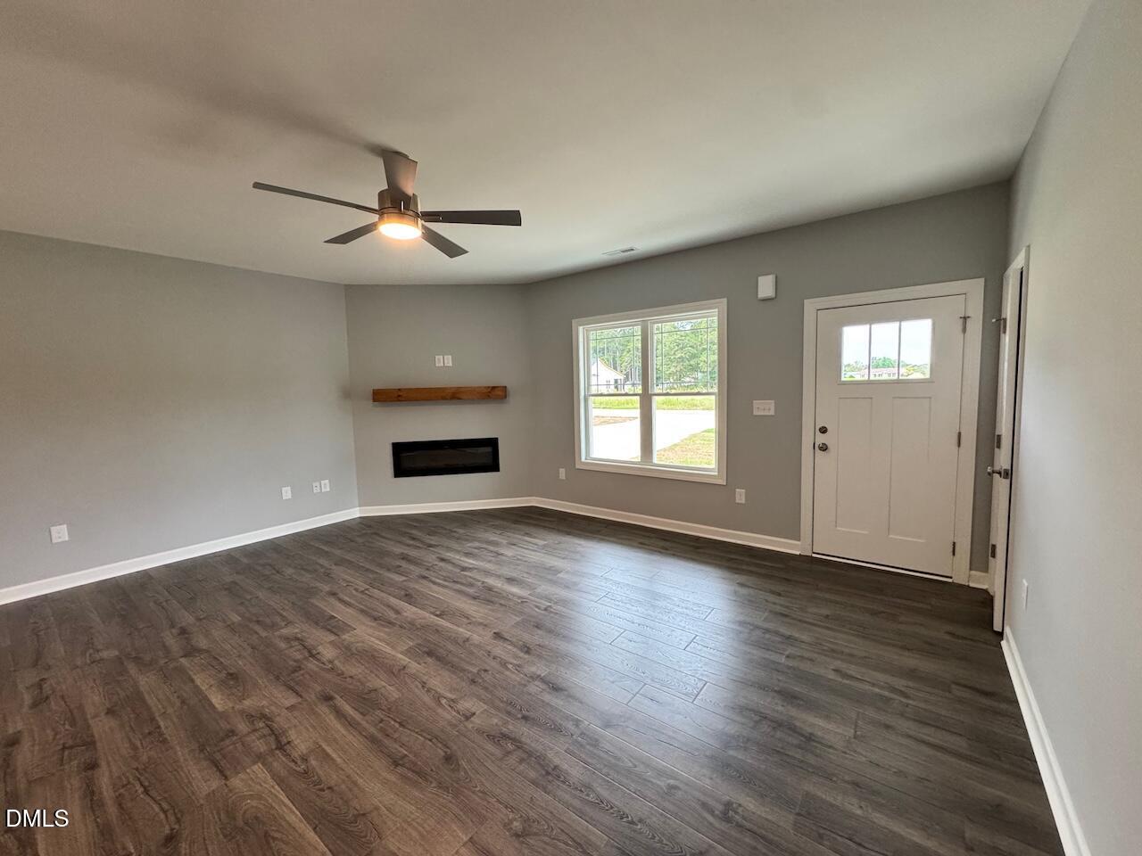 9 Alex Acres Way Selma, NC 27576 - Photo 4 of 26 an empty room with wooden floor ceiling fan and windows