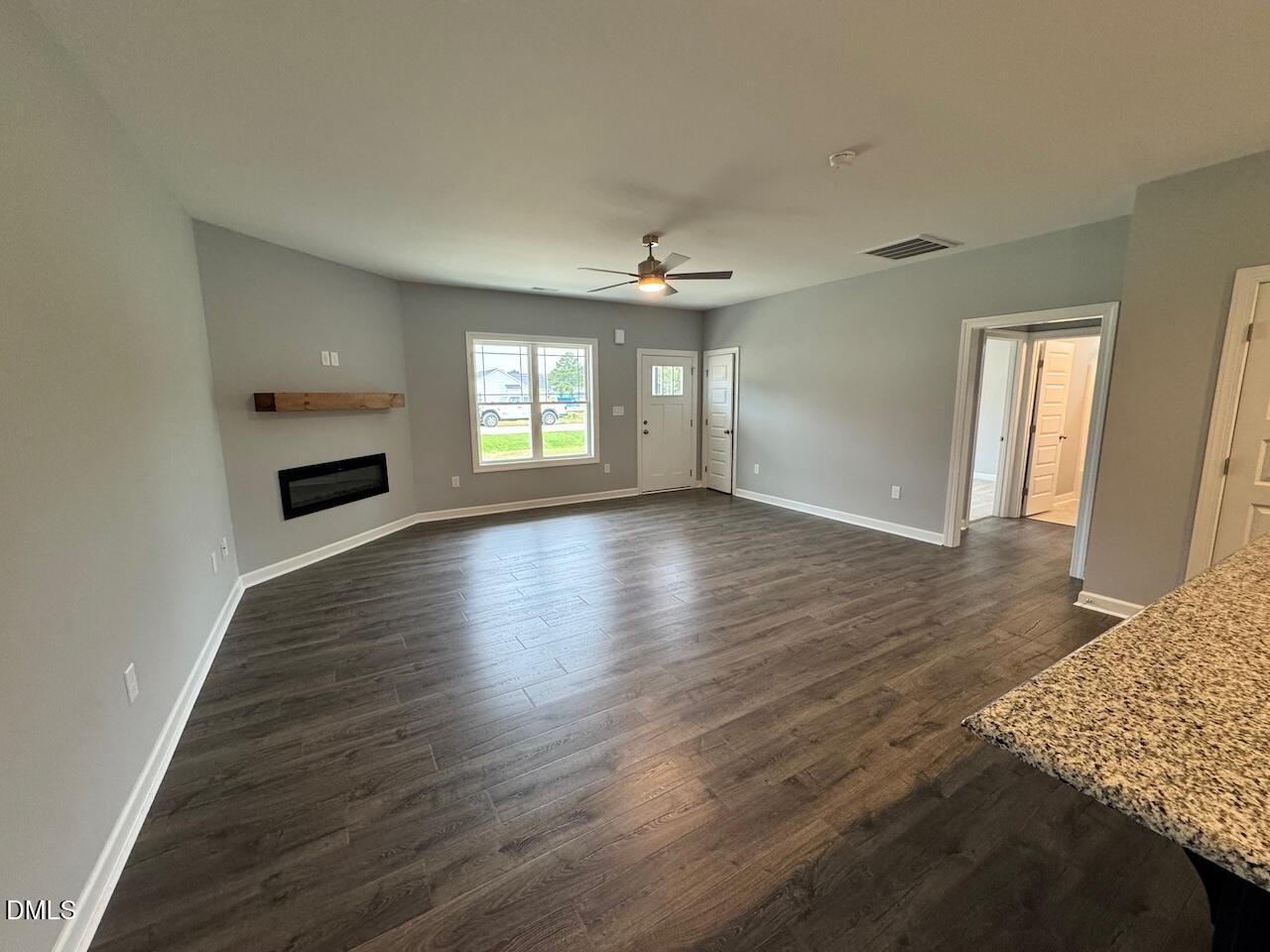 9 Alex Acres Way Selma, NC 27576 - Photo 6 of 26 an empty room with wooden floor fireplace and windows