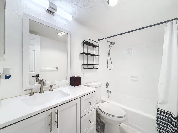 a bathroom with a sink a toilet and a mirror