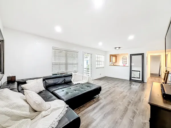a living room with furniture and a wooden floor
