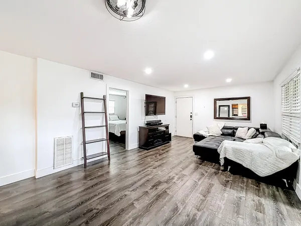 a living room with furniture and a wooden floor