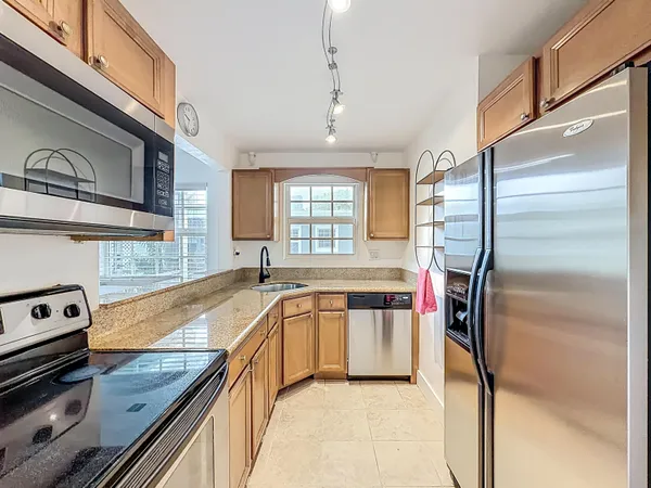 a kitchen with stainless steel appliances granite countertop a sink stove and refrigerator