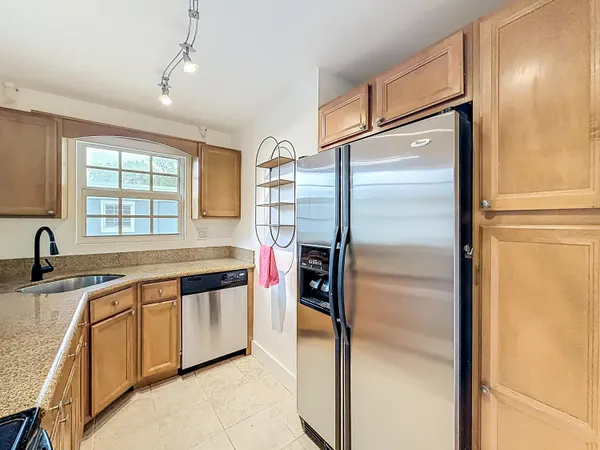 a kitchen with stainless steel appliances granite countertop a refrigerator and a sink